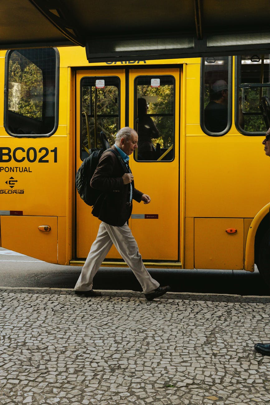 a man walking towards a yellow bus