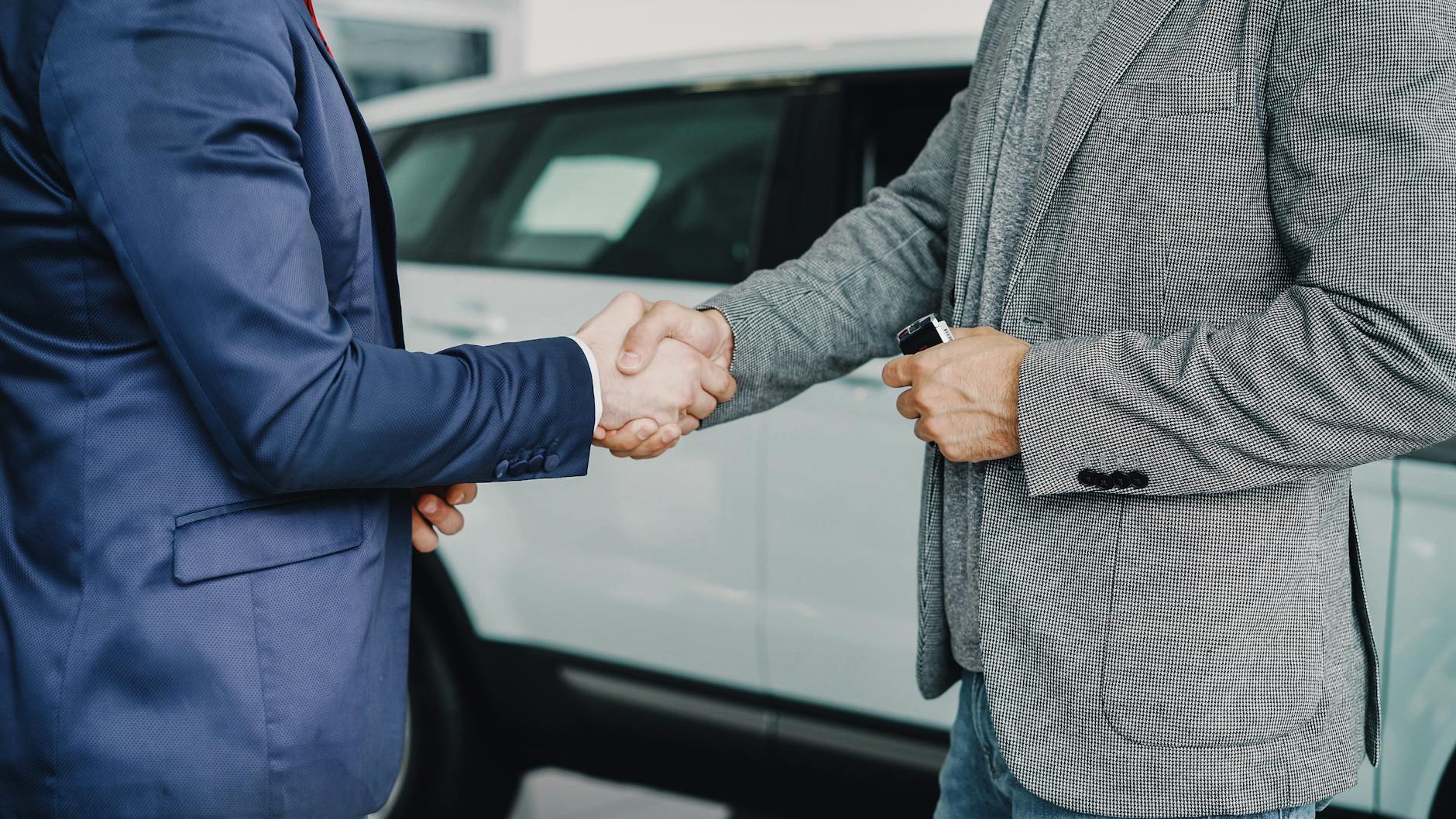 business handshake in car dealership
